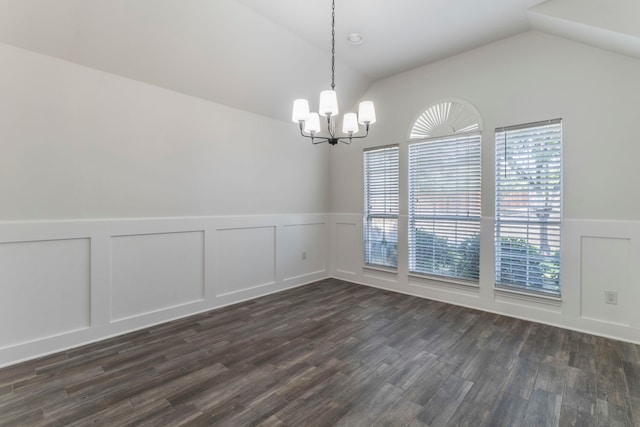 spare room with a chandelier, lofted ceiling, wainscoting, dark wood finished floors, and a decorative wall