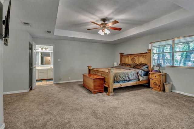 116 Nottingham Cir, Bridgeport, TX 76426 - bedroom with light colored carpet, a raised ceiling, baseboards, ensuite bath, and a textured ceiling