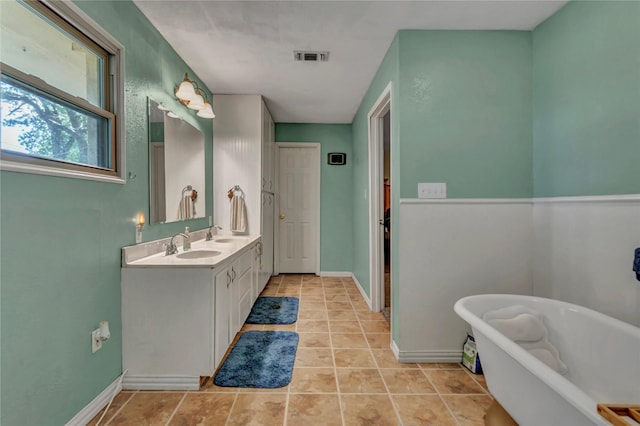116 Nottingham Cir, Bridgeport, TX 76426 - bathroom featuring a soaking tub, double vanity, tile patterned flooring, and baseboards