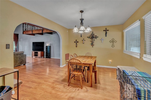 116 Nottingham Cir, Bridgeport, TX 76426 - dining room featuring arched walkways, a chandelier, light wood finished floors, and baseboards