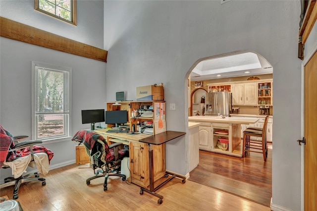 116 Nottingham Cir, Bridgeport, TX 76426 - office with arched walkways, a high ceiling, light wood-style floors, and baseboards