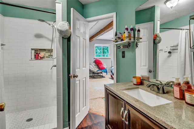 116 Nottingham Cir, Bridgeport, TX 76426 - full bath featuring a tile shower, vanity, beam ceiling, and wood finished floors