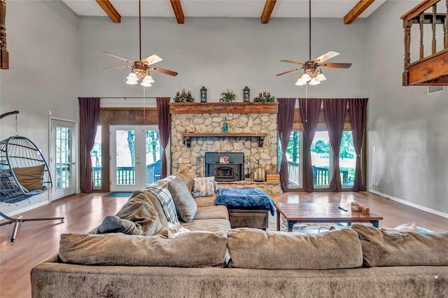 116 Nottingham Cir, Bridgeport, TX 76426 - living area featuring ceiling fan, a towering ceiling, wood finished floors, a wood stove, and beamed ceiling