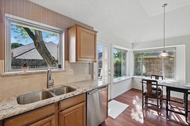kitchen with stainless steel dishwasher, a sink, a textured ceiling, tasteful backsplash, and dark wood-type flooring