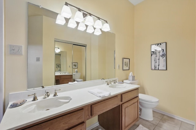bathroom with toilet, tile patterned flooring, double vanity, and baseboards