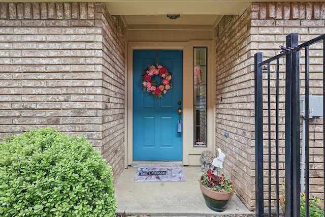 view of exterior entry featuring brick siding
