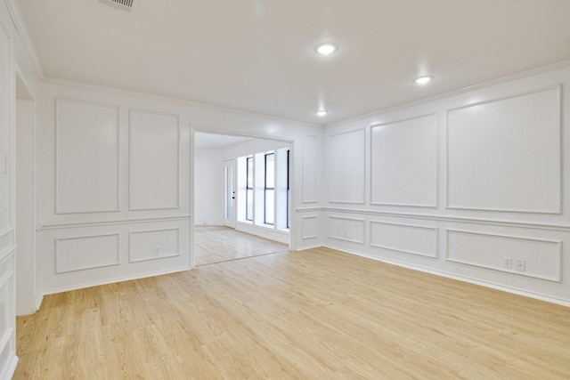 5129 Woodmeadow Ct, Garland, TX 75043 - spare room featuring a decorative wall, light wood-style flooring, ornamental molding, and recessed lighting