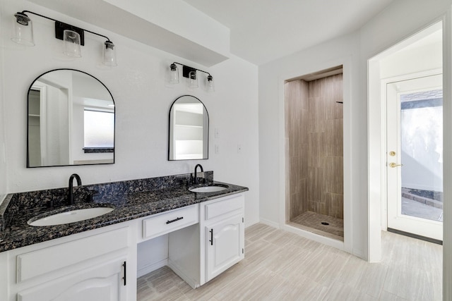 5129 Woodmeadow Ct, Garland, TX 75043 - full bath with healthy amount of natural light, a tile shower, double vanity, and baseboards