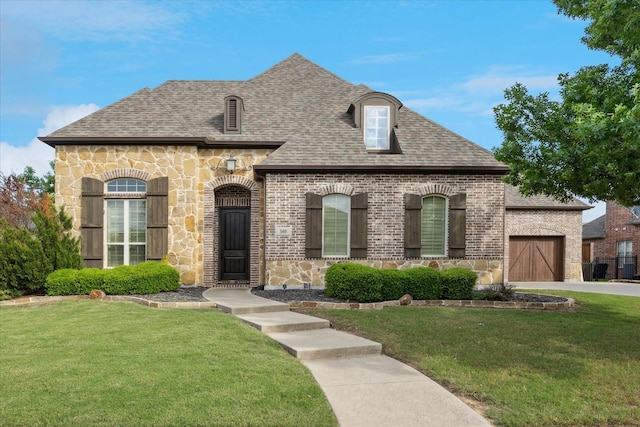french country inspired facade with stone siding, brick siding, a garage, and a front yard
