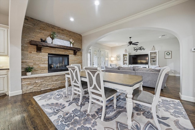 580 Butchart Dr, Prosper, TX 75078 - dining space with a ceiling fan, dark wood finished floors, a fireplace, arched walkways, and baseboards