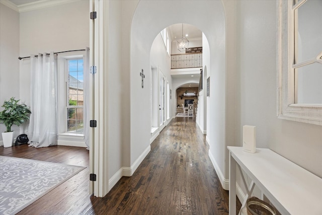 580 Butchart Dr, Prosper, TX 75078 - hallway featuring arched walkways, crown molding, dark wood-style flooring, baseboards, and a high ceiling