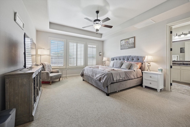 580 Butchart Dr, Prosper, TX 75078 - bedroom with carpet flooring, a tray ceiling, connected bathroom, and a ceiling fan