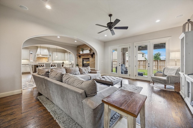 living room with arched walkways, ceiling fan, baseboards, dark wood finished floors, and recessed lighting