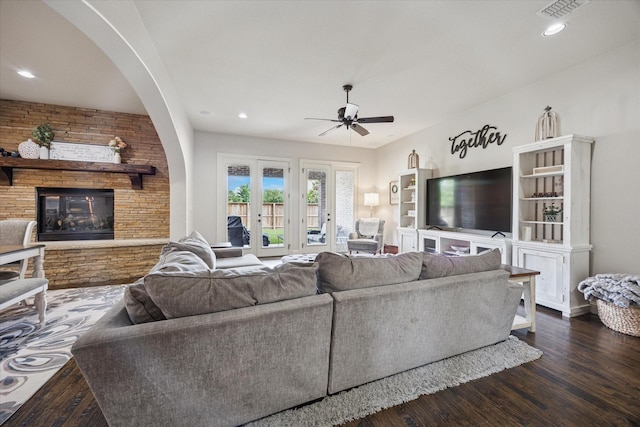 580 Butchart Dr, Prosper, TX 75078 - living area with ceiling fan, a large fireplace, dark wood finished floors, arched walkways, and recessed lighting