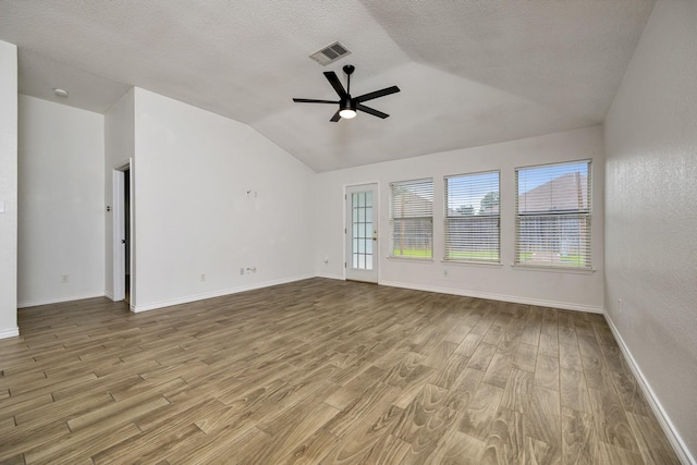 6717 Red Rock Trl, Watauga, TX 76137 - spare room with lofted ceiling, ceiling fan, wood finished floors, baseboards, and a textured ceiling