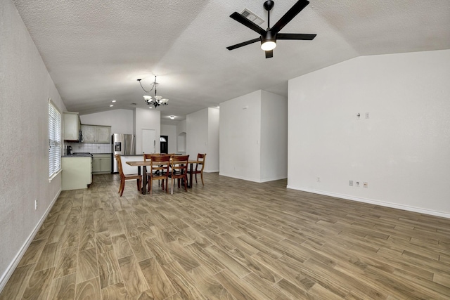 6717 Red Rock Trl, Watauga, TX 76137 - dining space with vaulted ceiling, light wood-style floors, a chandelier, a ceiling fan, and baseboards