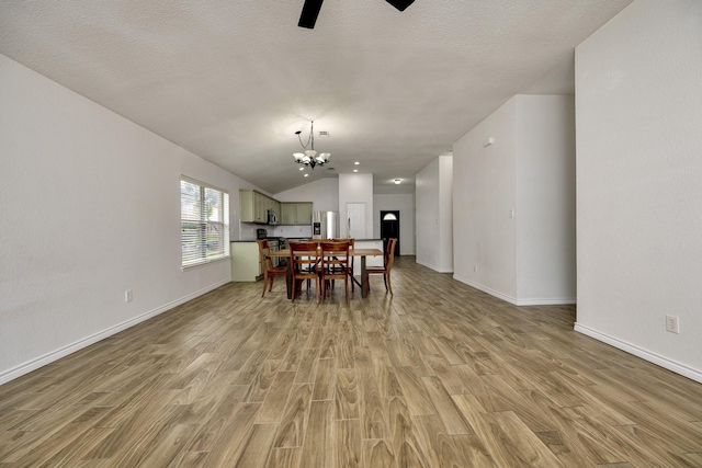 6717 Red Rock Trl, Watauga, TX 76137 - dining area featuring light wood-style floors, a chandelier, a ceiling fan, vaulted ceiling, and baseboards