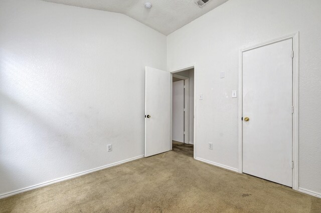 6717 Red Rock Trl, Watauga, TX 76137 - unfurnished bedroom with lofted ceiling, carpet flooring, and baseboards