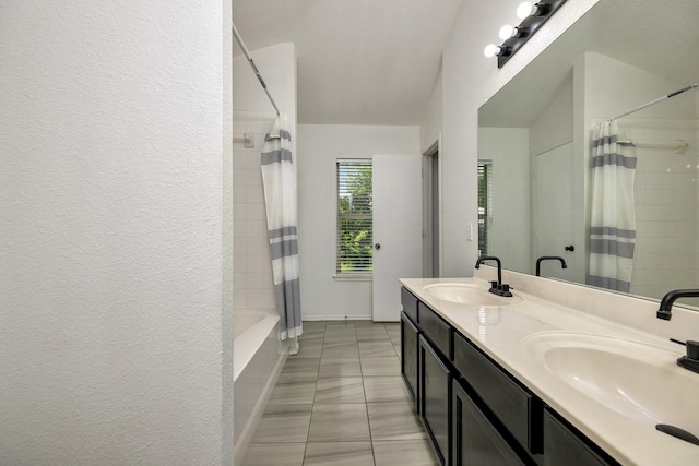 6717 Red Rock Trl, Watauga, TX 76137 - full bath with double vanity, shower / tub combo with curtain, a textured wall, and tile patterned floors