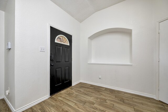 6717 Red Rock Trl, Watauga, TX 76137 - entryway with lofted ceiling, wood finished floors, and baseboards