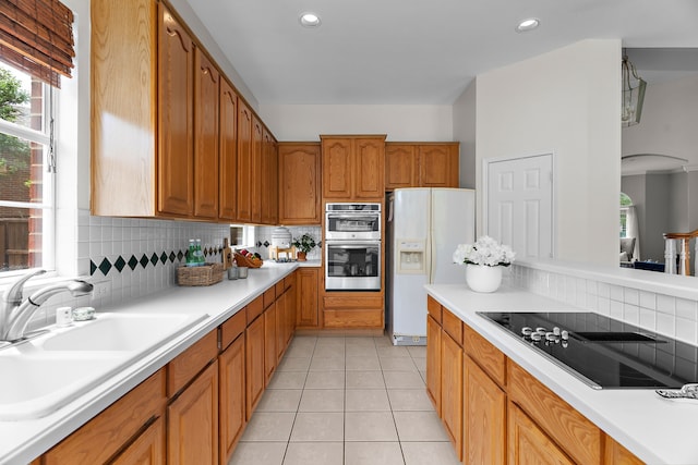 2830 Faversham Dr, Richardson, TX 75082 - kitchen featuring white refrigerator with ice dispenser, black electric stovetop, a sink, decorative backsplash, and light countertops