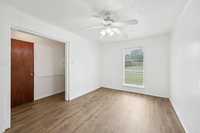 2115 Southridge Dr, Arlington, TX 76010 - unfurnished bedroom with wood finished floors, a textured ceiling, ceiling fan, and baseboards