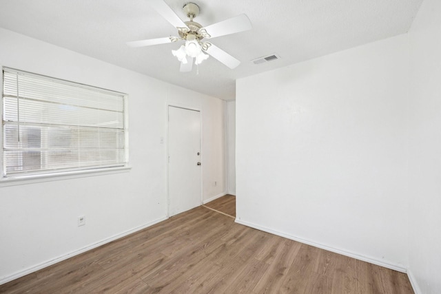 2115 Southridge Dr, Arlington, TX 76010 - unfurnished room with wood finished floors, a ceiling fan, and baseboards