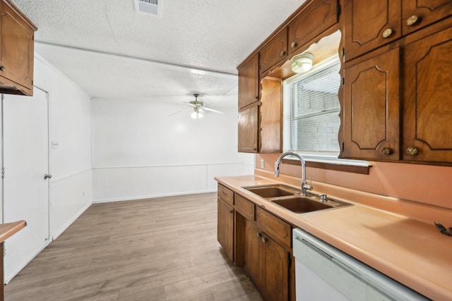 2115 Southridge Dr, Arlington, TX 76010 - kitchen featuring a sink, dishwasher, ceiling fan, light wood-style flooring, and light countertops