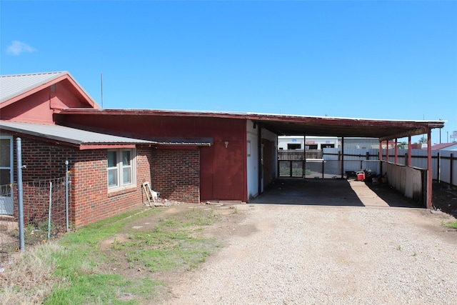 260 S Munday Ave, Munday, TX 76371 - view of side of property with driveway, fence, brick siding, and an attached carport