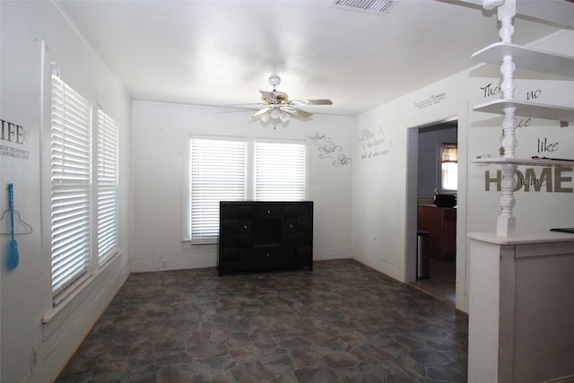 260 S Munday Ave, Munday, TX 76371 - unfurnished dining area with stone finish floors, plenty of natural light, and ceiling fan