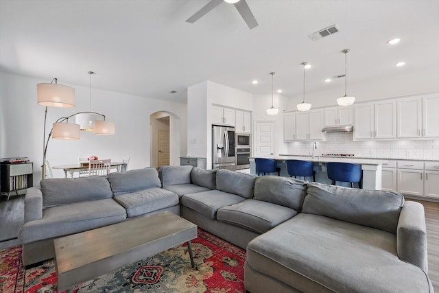 1606 Dreamers Way, Wylie, TX 75098 - living area featuring arched walkways, a ceiling fan, wood finished floors, and recessed lighting