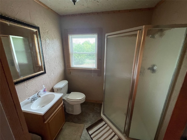 bathroom with a textured wall, a stall shower, toilet, and vanity