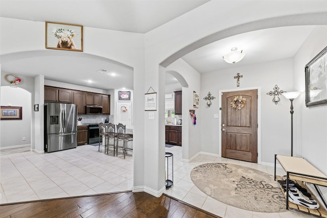239 Springwood Ranch Loop, Springtown, TX 76082 - entrance foyer featuring arched walkways, light wood-type flooring, and baseboards