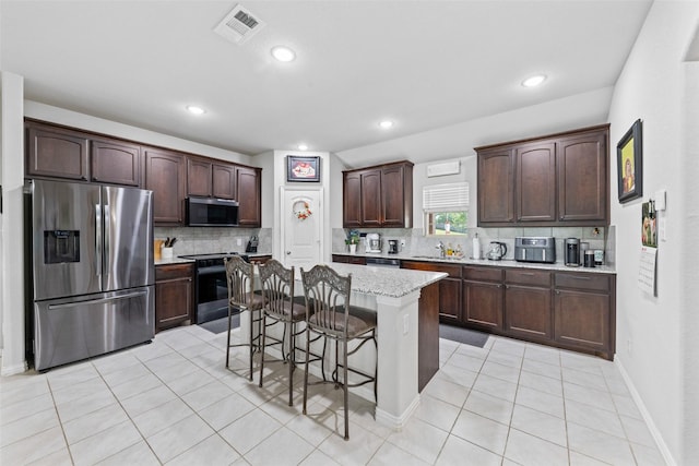 239 Springwood Ranch Loop, Springtown, TX 76082 - kitchen featuring stainless steel appliances, a breakfast bar area, backsplash, light tile patterned floors, and a sink