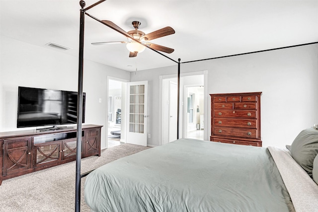 carpeted bedroom featuring ensuite bathroom and a ceiling fan
