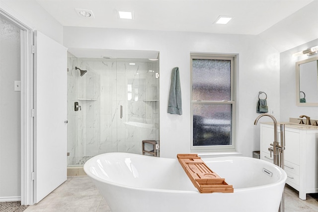 bathroom featuring a marble finish shower, a freestanding tub, vanity, and baseboards