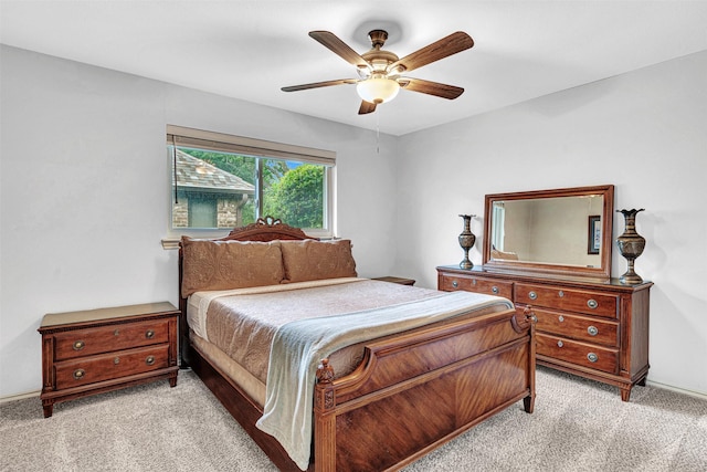 bedroom with light carpet, a ceiling fan, and baseboards