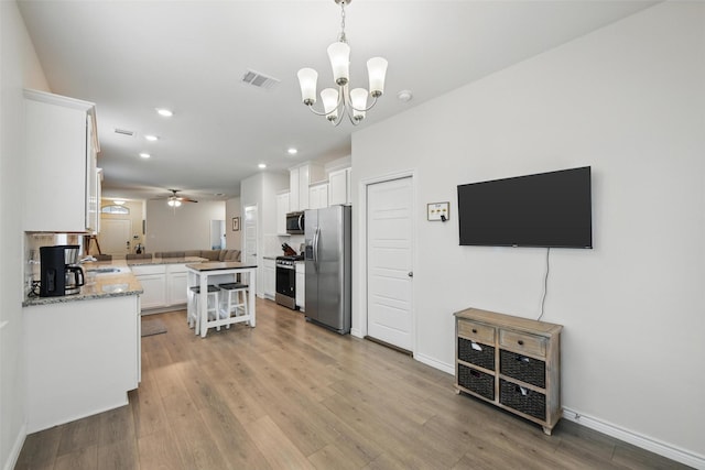 kitchen featuring appliances with stainless steel finishes, white cabinets, light wood-type flooring, and recessed lighting