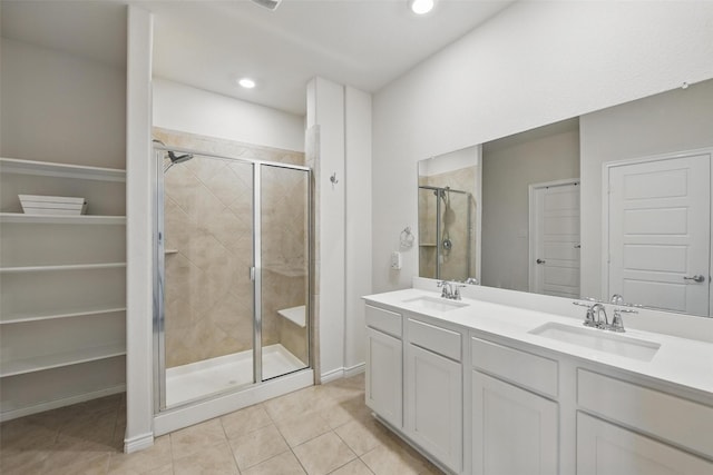 bathroom featuring a shower stall, tile patterned flooring, double vanity, and recessed lighting