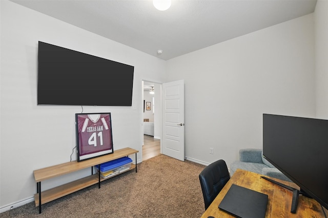 carpeted home office featuring baseboards