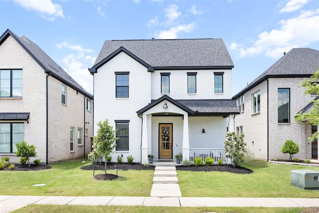 3545 W Cheney Ave, Celina, TX 75009 - view of front of property featuring brick siding, roof with shingles, a front yard, and a porch
