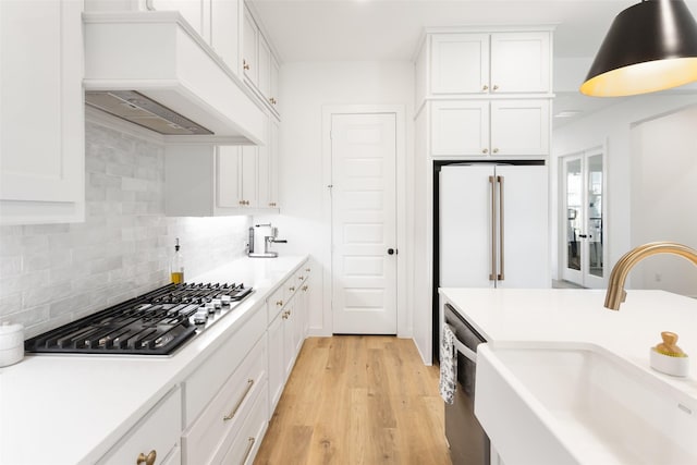 3545 W Cheney Ave, Celina, TX 75009 - kitchen featuring custom exhaust hood, a sink, appliances with stainless steel finishes, white cabinets, and light wood-type flooring