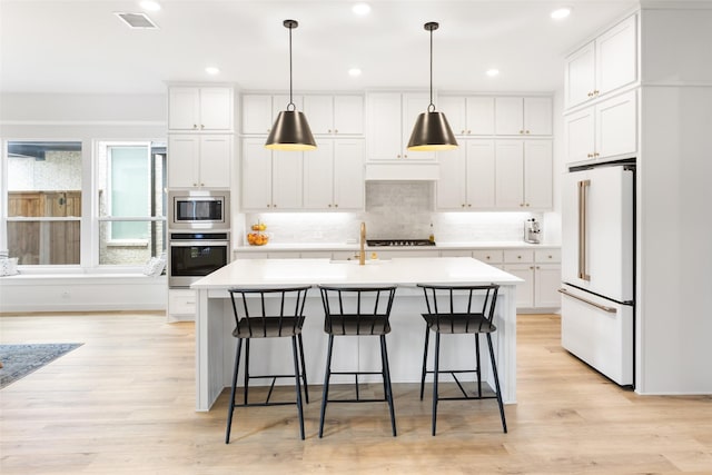 3545 W Cheney Ave, Celina, TX 75009 - kitchen featuring appliances with stainless steel finishes, white cabinetry, an island with sink, decorative backsplash, and recessed lighting
