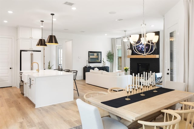 3545 W Cheney Ave, Celina, TX 75009 - dining space featuring a chandelier, light wood-type flooring, recessed lighting, and a fireplace