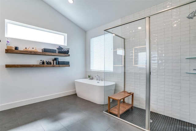 full bathroom featuring lofted ceiling, tile patterned floors, a stall shower, plenty of natural light, and a freestanding bath