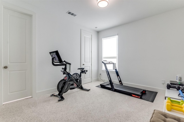 exercise area featuring baseboards and carpet flooring