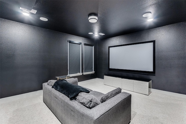 carpeted home theater with a textured wall, baseboards, and a textured ceiling
