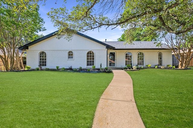 ranch-style house featuring brick siding, a front yard, and a shingled roof