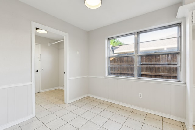 spare room with light tile patterned floors and baseboards