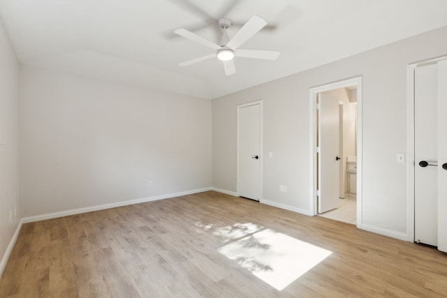 unfurnished bedroom featuring light wood finished floors, baseboards, ensuite bath, and ceiling fan